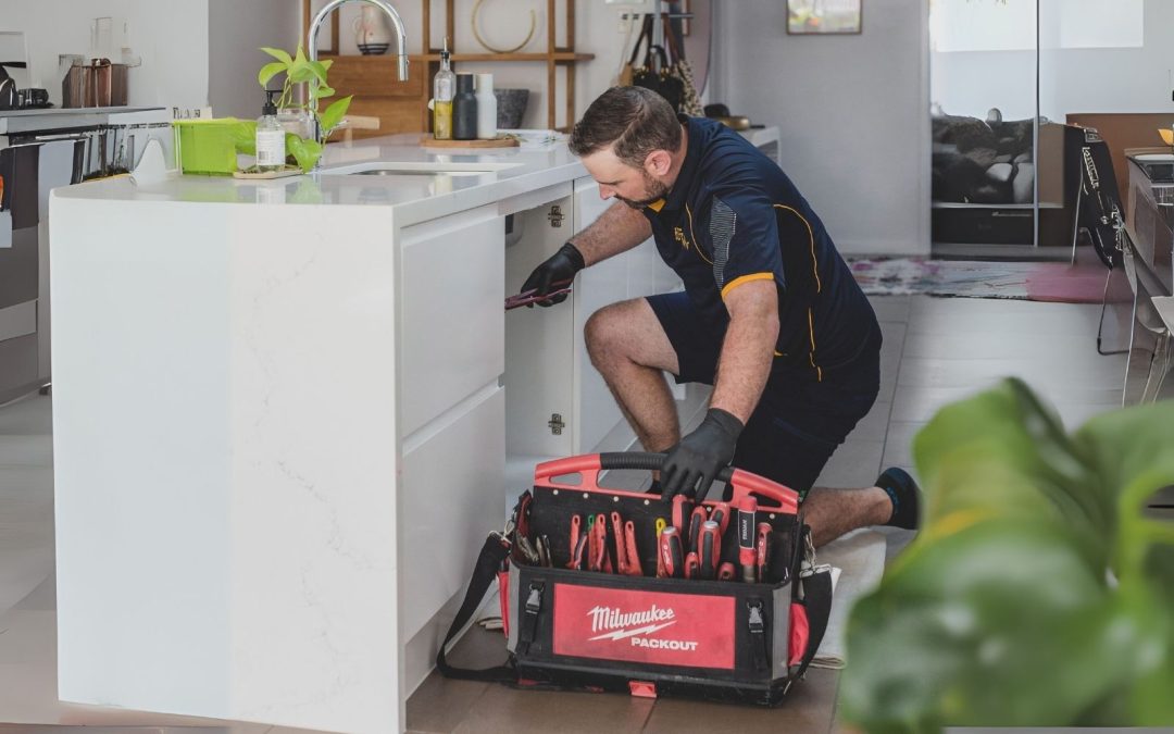 plumber working in kitchen gold coast