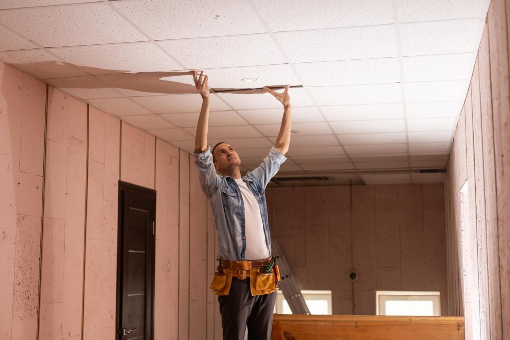 electrician fixing wires, installing light on the ceiling