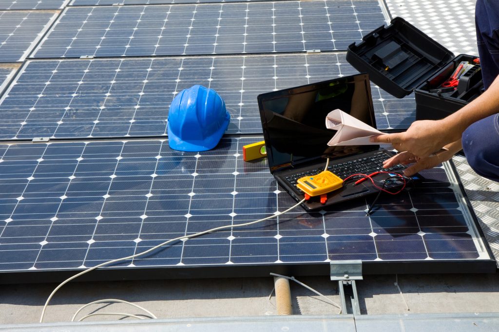 Worker testing solar panel output